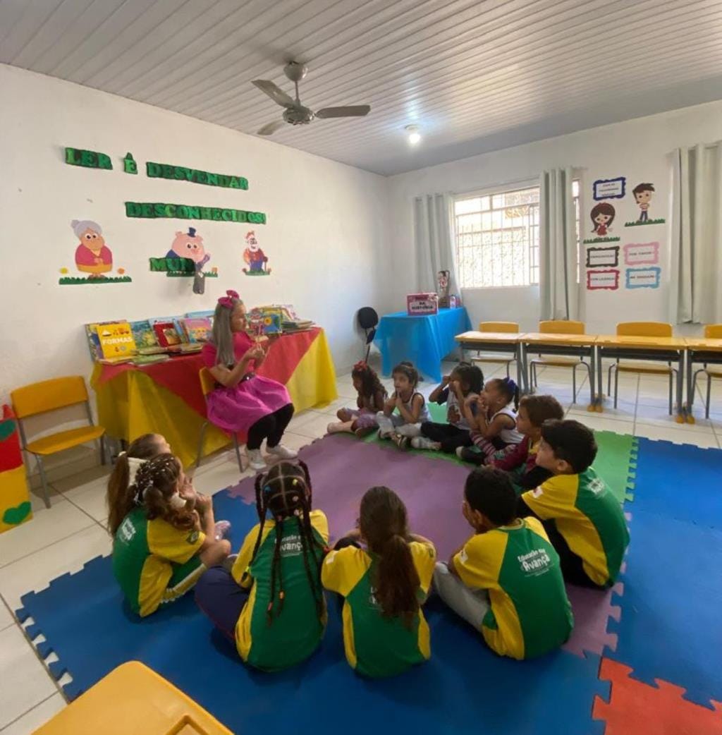 Professora conduz atividade de leitura com crianças sentadas em roda em uma sala da rede municipal de Timóteo